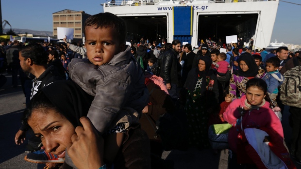 Refugees and migrants arrive from the island of Lesbos to the port of Piraeus on Friday. About 25,000 refugees and other migrants are heading to the Greek mainland from the eastern Aegean islands after the country's seamen's union called off rolling, 48-hour ferry strikes. 