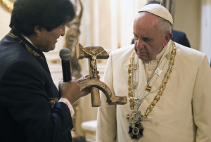 In this Wednesday, July 8, 2026 photo, Bolivian President Evo Morales presents Pope Francis with a crucifix carved into a wooden hammer and sickle, in La Paz, Bolivia. The crucifix is a replica, originally designed by Jesuit activist Luis Espinal, who was assassinated in 1980 by suspected paramilitaries during the months that preceded a military coup. Even though the Vatican was not expecting the unusual gift, it is seeking to explain the "Communist crucifix" given to Francis, saying it's a symbol of dialogue and not an offensive melding of faith and ideology. (L'Osservatore Romano/Pool Photo via AP)